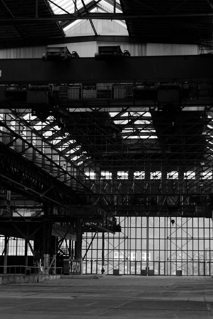 Black and white photograph of an empty, industrial warehouse interior located in Amsterdam, Netherlands.
